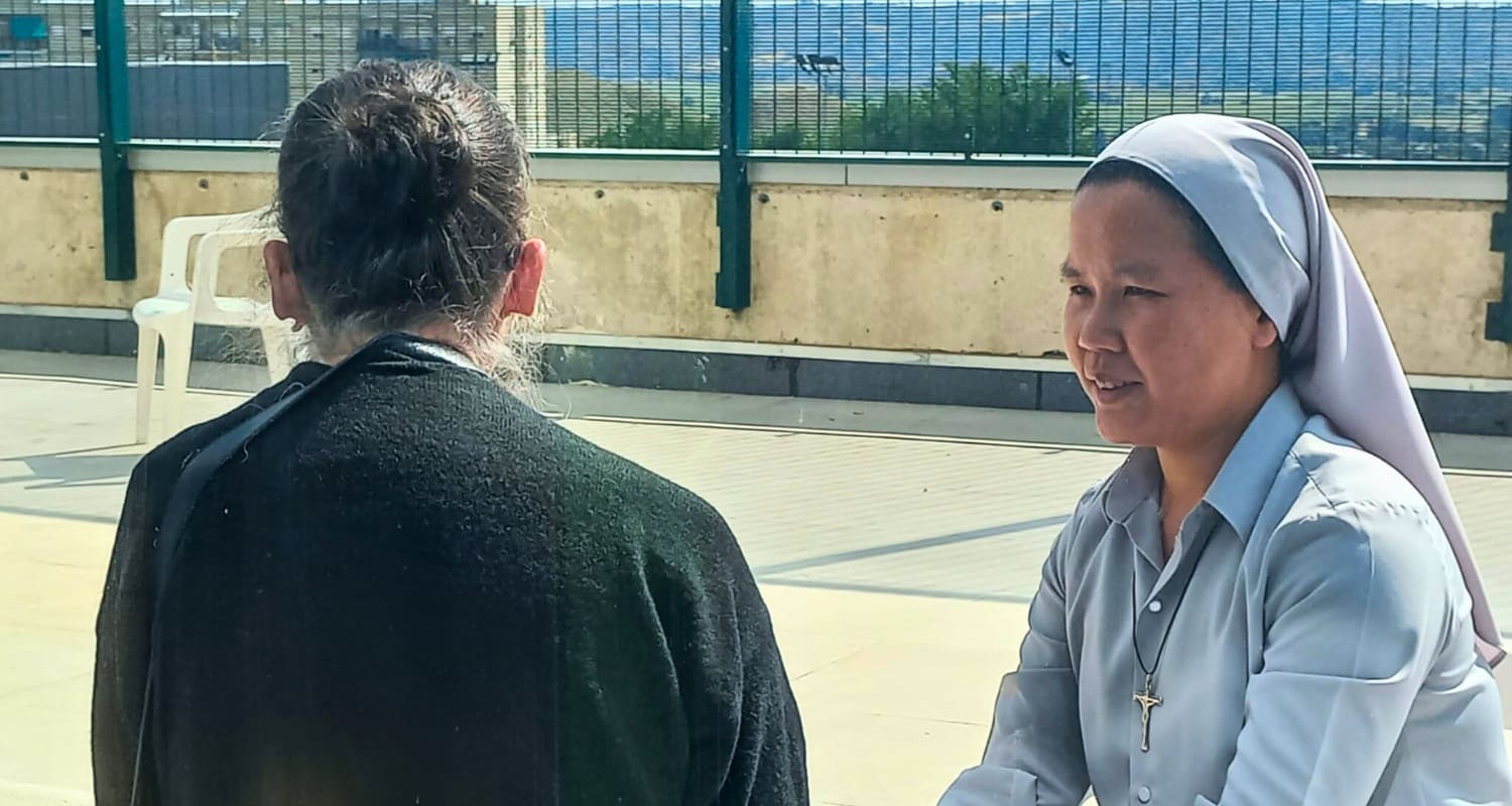Hna. Anna Kha esuchándo y soteniendo la mano de otra mujer