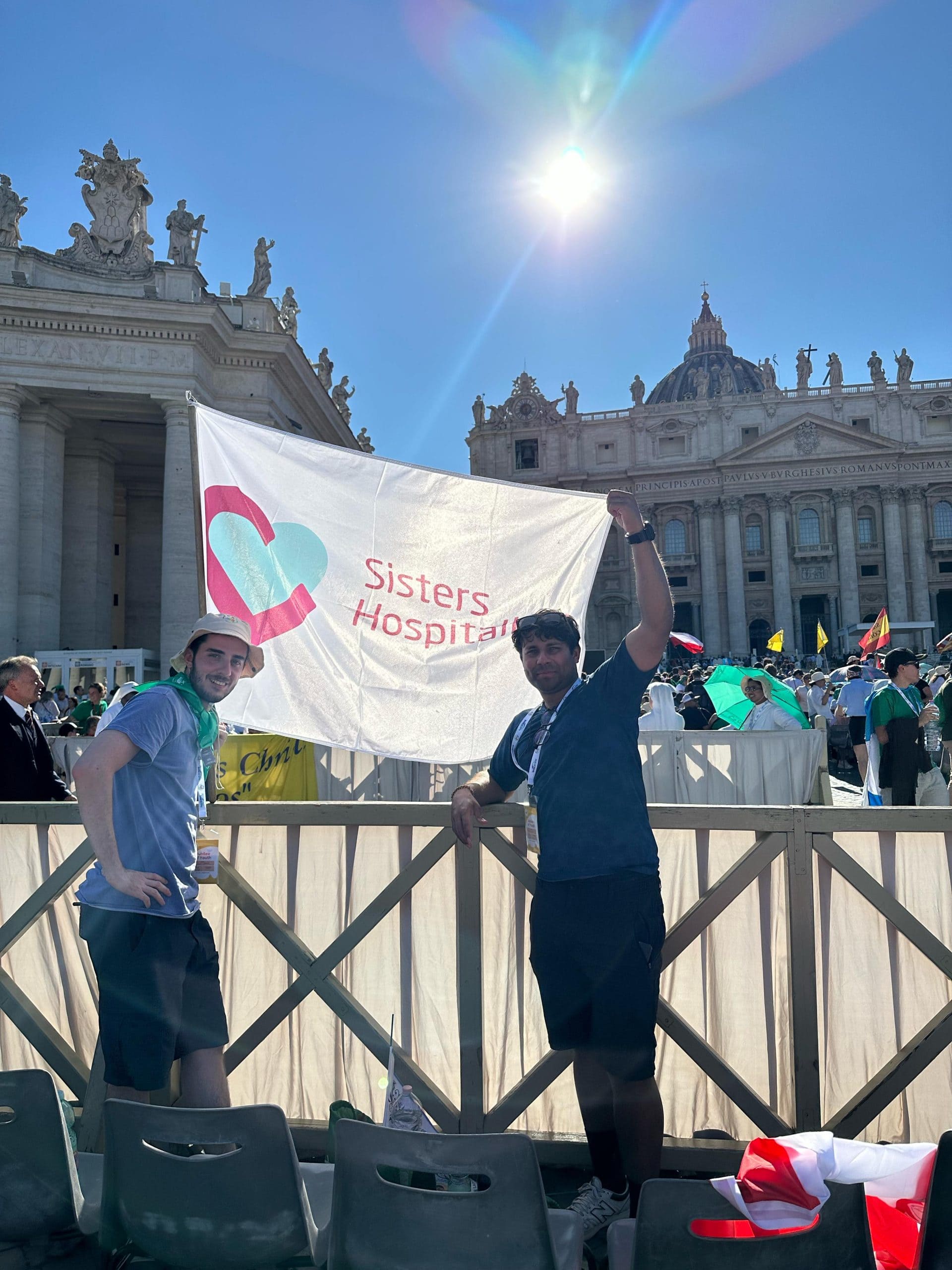 Dos Jóvenes hospitalarios ondeando una bandera de Hermanas Hospitalarias
