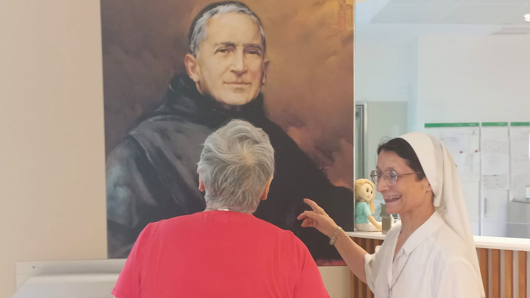 Hna. Gabrielle Lillon señalando a un cuadro de la Congregación
