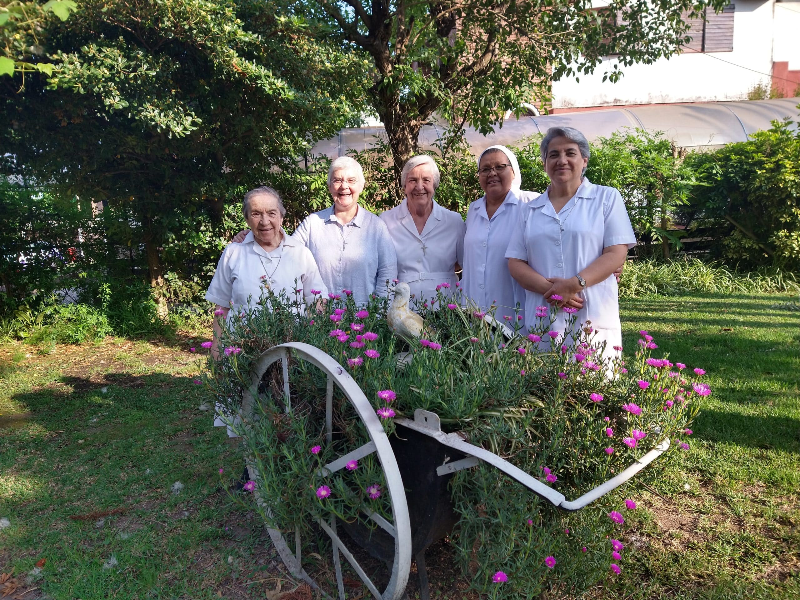 cuatro Hermanas Hospitalarias reunidas en un jardín